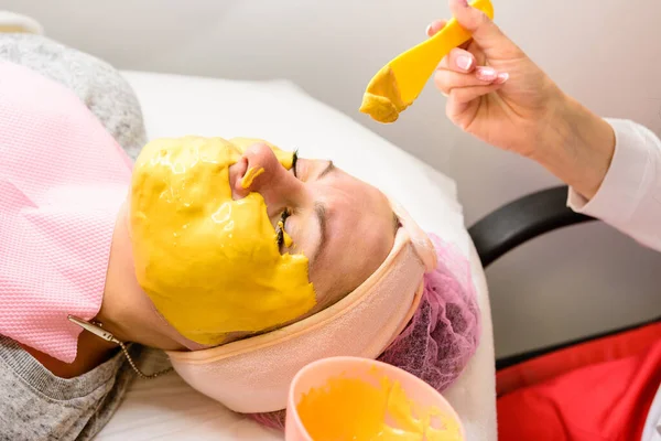 Återfuktar Huden Spa Den Kosmetolog Applicerar Guldmask Kundens Ansikte Nya — Stockfoto