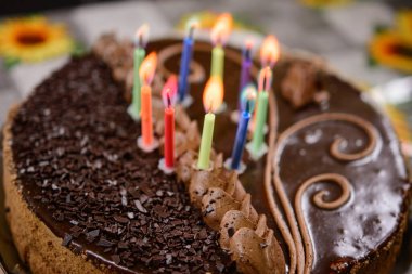 Bayram pastasında renkli mumlar yakmak, çocuğun onuncu yıldönümü. yeni