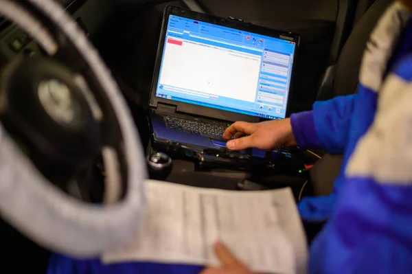 Computer diagnostics of the onboard computer in the car in a car dealership.