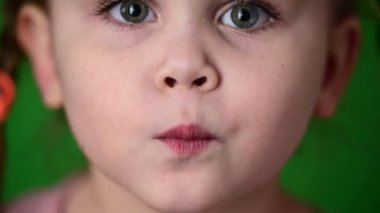 Kameradaki kız bir öpücük gösteriyor, şirin bebek yüzü yakın plan.