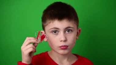 9 yaşındaki bir çocuk elinde diş hizalama plakası, iğrenç bir şey ve diş hizalama plakası tutuyor..