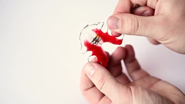 Revisione di una piastra per bambini per allineare i denti, revisione su sfondo bianco. — Video Stock