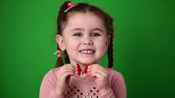 Het kind onderzoekt en demonstreert een gebit plaat om kromme tanden recht te zetten. — Stockvideo