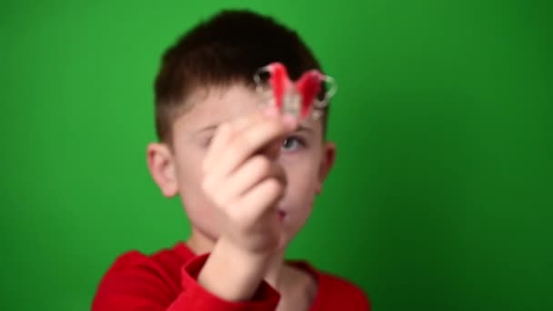 Plaat voor het uitlijnen van tanden, een jongen op een groene achtergrond met een plaat, een tandartsbord in zijn handen. — Stockvideo