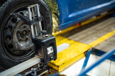 Arabadaki tekerleklerin düzensizliğinin ayarlanması için sensör, araba servisinde çalışmak, araç gereçleri.