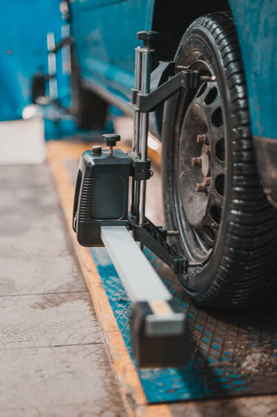 Close-up of a tire clamped by a leveler that passes the automatic alignment of the wheels in the garage, garage and tools for the mechanic. new