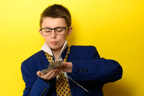 Chlapec Obleku Pro Dospělé Žlutém Pozadí Mezinárodní Měna Rukou Dítěte — Stock fotografie