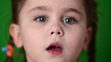 Kameradaki kız bir öpücük gösteriyor, şirin bebek yüzü yakın plan.