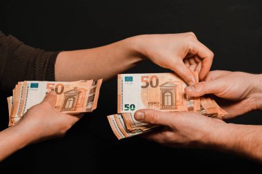 İnsanlar para sayıyor, kadın ve erkek avroluk banknotları sayıyor, para siyah arkaplanda. yeni