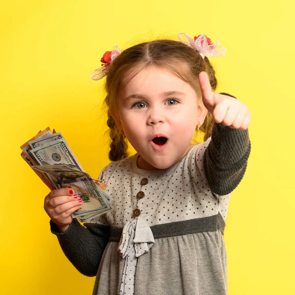 Милая Маленькая Девочка Жёлтом Фоне Держит Мировую Валюту Финансовую Грамотность — стоковое фото