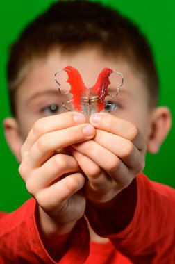 Deforme olmuş dişleri hizalamak için diş ipini elinde tutuyor. yeni