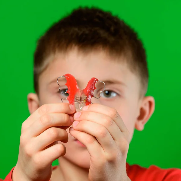Rapaz Fundo Verde Mostra Prato Para Alinhar Dentes Novo — Fotografia de Stock