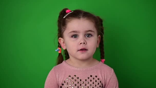 미소짓는 작고 귀여운 소녀, 행복하고 즐거운 아기, 녹색 배경. — 비디오