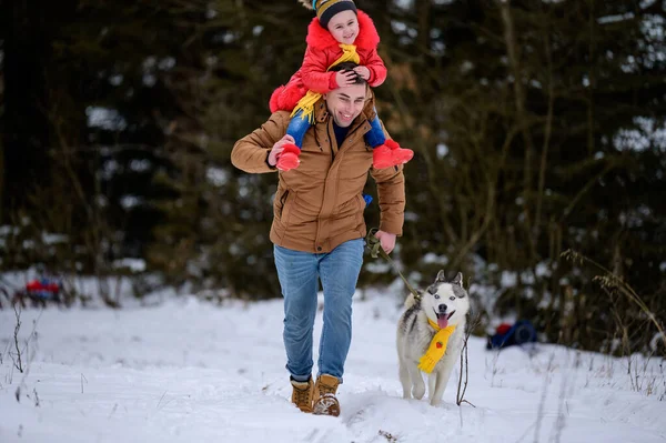 犬と一緒にジョギングし 暗い森の中を歩く幸せな家族 楽しい冬のゲーム新しい — ストック写真