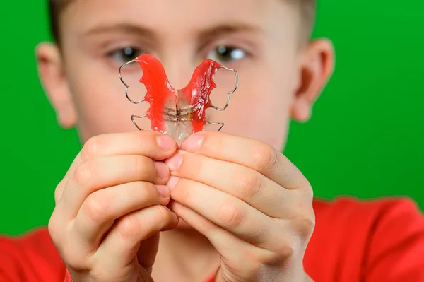 Rapaz Fundo Verde Mostra Prato Para Alinhar Dentes Novo — Fotografia de Stock