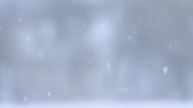 Kar taneleri kışın yavaş çekimde Bokeh 'ten düşer. Kar yağışlı büyüleyici bir video..
