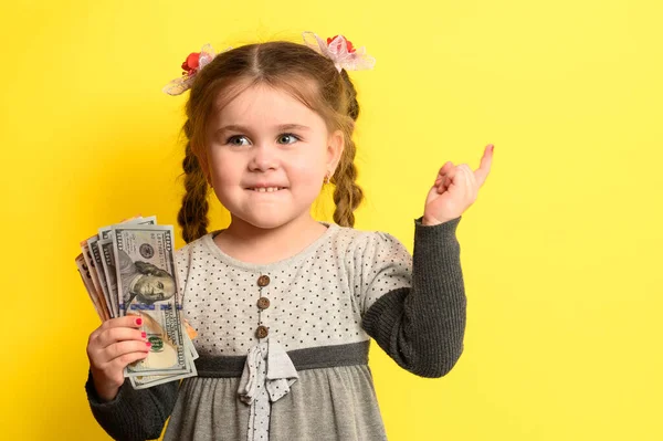 白人の少女 黄色の背景に子供の肖像画 子供の金融リテラシーを保持する 新しい — ストック写真