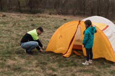 Bir baba ve kız, ağaçlarla çevrili çimenli bir çayıra canlı bir çadır kurmak için birlikte çalışırlar. Sakin bir öğleden sonra, büyük açık havada anılar yaratırlar..