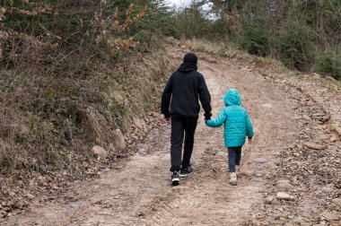 İki genç kardeş, ağaçlarla çevrili dolambaçlı toprak patika boyunca el ele yürür. Serin hava, huzur dolu araziyi keşfederken biraz macera katıyor..