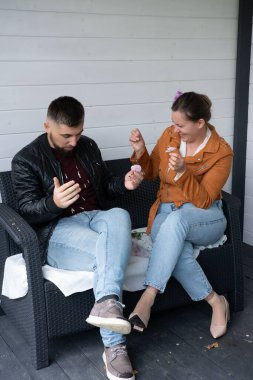 İki arkadaş neşeli maskaralıklara dalarken keyif alırlar, büyüleyici bir sundurma atmosferiyle çevrili, neşeli bir toplantı sırasında gülmek ve iletişim kurmak için mükemmel bir ortam..