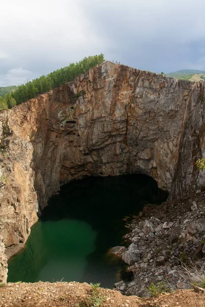 Technogenic pit hole hollow with water, a former mine for the extraction of minerals - Tuim sinkhole, Republic of Khakassia, photo