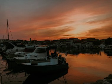 Denizde bir sürü yat, tekne ve gemi var. Gün batımında Marina.