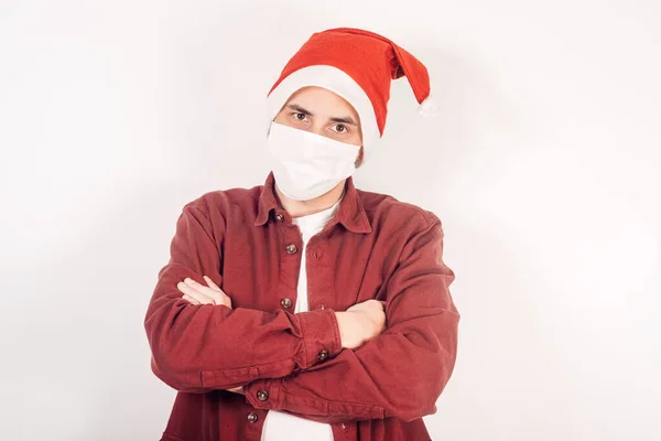 Noel Baba şapkalı ve maskeli adam kızgın. Yeni yıl karantinası. Noel geçidi. Rostroen adam