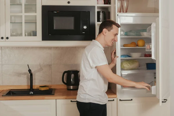 Man Stands Kitchen Looks Refrigerator Does Know What Eat Thinks — Stock Photo, Image