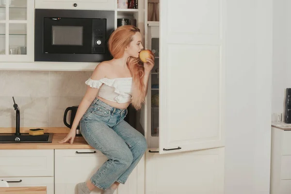 Una Mujer Está Sentada Casa Cocina Cerca Del Refrigerador Una — Foto de Stock