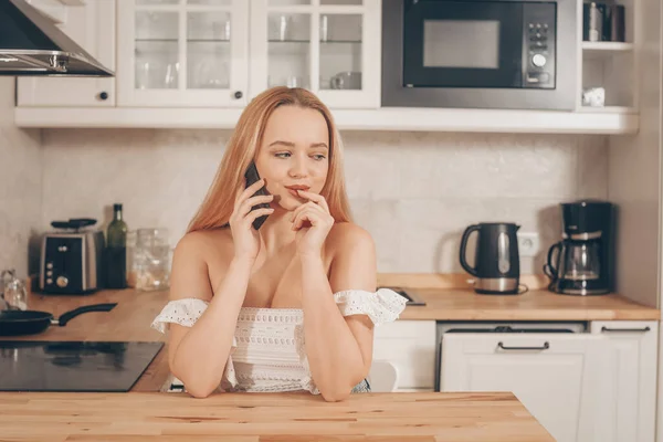 Mulher Bonita Senta Uma Mesa Fundo Cozinha Casa Menina Fala — Fotografia de Stock