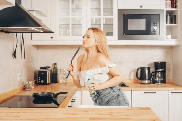 Mulher Cantando Dançando Cozinha Com Smartphone Música Uma Menina Fones — Fotografia de Stock