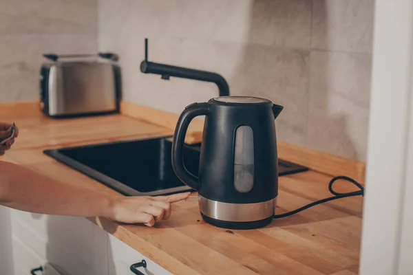 Black Kettle Kitchen Table Woman Hand Presses Button Teapot Make — Stock Photo, Image