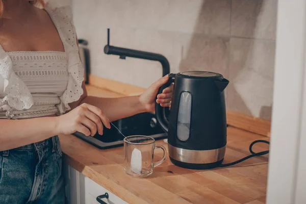 Está Uma Chaleira Preta Mesa Cozinha Mão Uma Mulher Segura — Fotografia de Stock