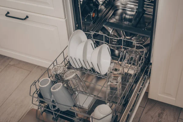 Built-in dishwasher in the kitchen, washing dishes. Plates, cups, glasses are worth washing. Household chores, everyday life