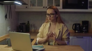 Dizüstü bilgisayarın arkasındaki kadın evde çalışıyor. Ceketli ve gözlüklü güzel bir sarışın görüntülü konuşma yapıyor. Öğretmen dersler veriyor, internette dersler veriyor. Serbest öğretmen.