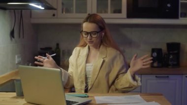Dizüstü bilgisayarın arkasındaki kadın evde çalışıyor. Ceketli ve gözlüklü güzel bir sarışın görüntülü konuşma yapıyor. Öğretmen dersler veriyor, internette dersler veriyor. Serbest öğretmen.