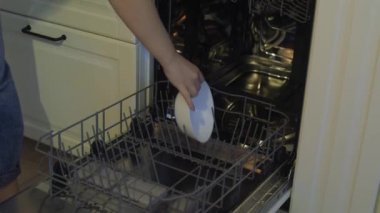 Dahili bulaşık makinesi, bulaşık makinesi. Bulaşıkları, bardakları, bardakları yıkayan bir kadın. Bir kadının nazik eli bulaşık makinesine bir şey koyar ya da çıkarır, boşaltır..