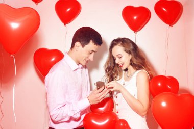 Erkek, tatlı kızına hediye yapar. Sevgililer Günü 'nde. Sevgililer Günü. Oğlan kız arkadaşına mücevher verir. Evlilik yüzüğü. Arka planda kırmızı balon kalpleri teklif et. Gülümse kızım..