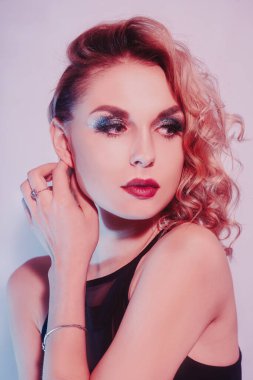 Gümüş ve elmaslı sarışın, obezite, küpeler, yüzükler. Güzel uzun tırnaklı ve manikürlü bir kadın. Parlak makyajlı bir kız. Parlak makyaj, kırmızı dudaklar.