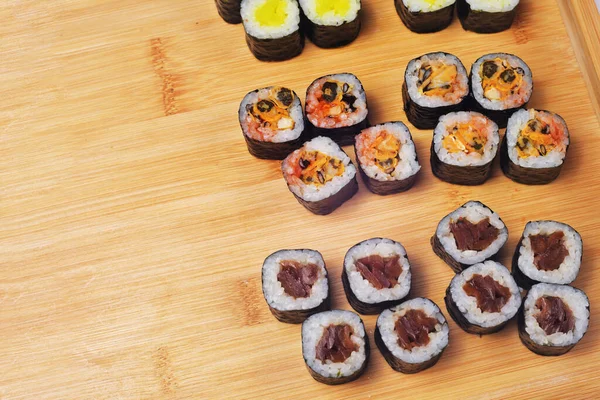 Sushi Egy Deszkán Fekszik Maki Sok Sushi Rizs Nori Töltelék — Stock Fotó