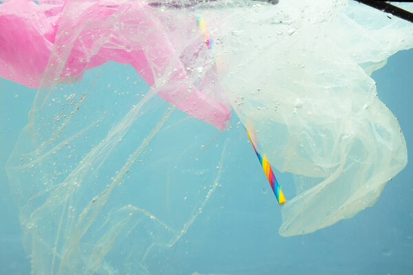 Загрязнение океана, воды. Пластик и обломки плавают в воде. Пакеты и банки были брошены в море.