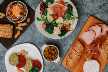 Et tabağı ve peynirli peynirli baget. Prosciutto ile salata. Zeytin. Mantarlı ve baharatlı mükemmel sahanda yumurta. Vejetaryen sebze pirzolası ve fıstık. Çatal. Yemek teslimatı.