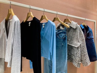 Mağazadaki askılarda asılı giysiler. Askıda asılı basit gardırop kazakları.