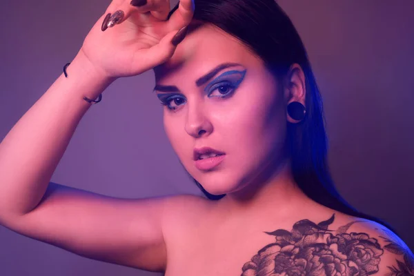 Брюнетка Татуировкой Цветов Плече Тоннелями Ушах Прекрасном Синем Свете Женщина — стоковое фото