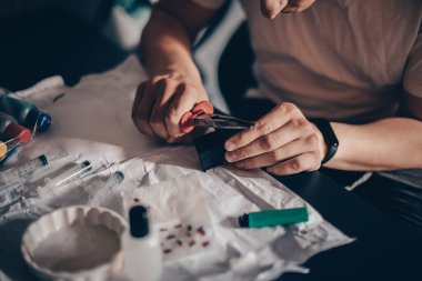 Erkek eller yazıcı kartuşunu doldurur. Adam kartuşta delikler açıyor ve şırıngaya mürekkep döküyor. İğne kartuşta bir delik açıyor.