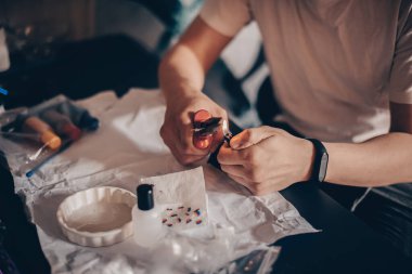 Erkek eller yazıcı kartuşunu doldurur. Adam kartuşta delikler açıyor ve şırıngaya mürekkep döküyor. İğne kartuşta bir delik açıyor.