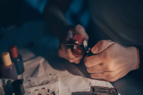 Male hands refill printer cartridge. The guy makes holes in the cartridge and pours ink through the syringe The needle makes a hole in the cartridge