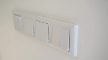 El ışığı kapatır ve açar. Enerji tasarrufu. Işık düğmesi. Parmak düğmeye basar