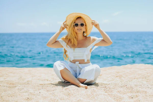 Happy Girl White Outfit Sits Sand Backdrop Sea Ocean Beach — Stock Photo, Image