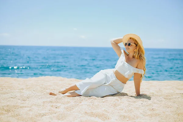 Happy Girl White Outfit Sits Sand Backdrop Sea Ocean Beach — Stock Photo, Image